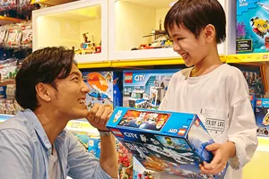 alt="400種類以上のレゴ商品が集まる大阪のレゴ🄬ショップで買い物を楽しむ親子"