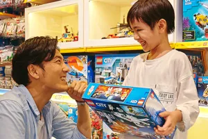 alt="400種類以上のレゴ商品が集まる大阪のレゴ🄬ショップで買い物を楽しむ親子"