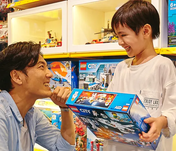 alt="400種類以上のレゴ商品が集まる大阪のレゴ🄬ショップで買い物を楽しむ親子"