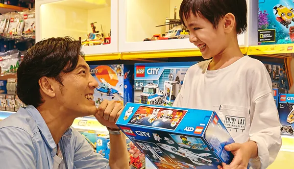 alt="400種類以上のレゴ商品が集まる大阪のレゴ🄬ショップで買い物を楽しむ親子"